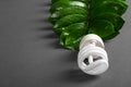 LED lamp with green leaf, ECO energy concept, close up. Light bulb on grey background. Saving and Ecological Environment. Copy sp Royalty Free Stock Photo
