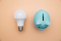 LED light bulb and blue piggy bank. Power energy economy concept
