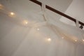 LED light garland on white curtain tulle on a rail