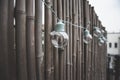 LED mint color light bulbs with wires hanging on a bamboo screen wall outside on a deck Royalty Free Stock Photo