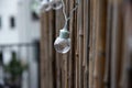 LED mint color light bulbs with wires hanging on a bamboo screen wall outside on a deck Royalty Free Stock Photo