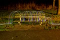 LED's jumping over a bench in a park