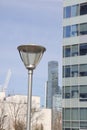 LED street lamp post glowing on skyscraper background. Modern led lights in city, saving of electrical energy. Royalty Free Stock Photo