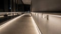 LED strip lights under corridor handrails create an energysaving pathway the fixtures sharp against a blurred walkway Royalty Free Stock Photo
