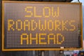 LED traffic control road sign solar powered message board mobile trailer variable message signs displaying Slow Roadworks Ahead Royalty Free Stock Photo
