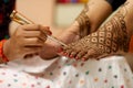 Ledy Feet and Hands in Heena for wedding in Orange and red background and isolated hand and feet