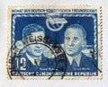 An old blue east german postage stamp with an image celebrating german soviet cooperation