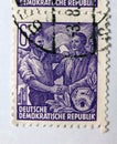 An old purple east german postage stamp with an image of workers shaking hands