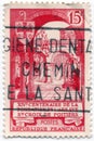 An old red french postage stamp issued in 1957 with an image celebrating the foundation of the Holy Cross Abbey in Poitiers