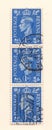 A row of old blue british penny postage stamps from the reign of king george the sixth