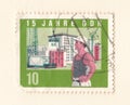 An old green east german stamp with an image of a construction worker on a building site with a crane
