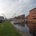 the leeds lock entrance to clarence dock with footbridge over the river aire and lock gates and mooring area surrounded by modern Royalty Free Stock Photo