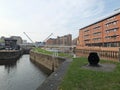 the leeds lock entrance to clarence dock with footbridge over the river aire and historic gates and mooring area surrounded by Royalty Free Stock Photo