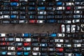 Aerial view directly above a scrap metal yard with rows of damaged cars