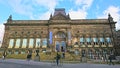 front view of the exterior and facade of Leeds City Museum under a bright blue sky