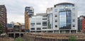 View of leeds with the river aire entering the dark arches under the railway station with pedestrian footbridge and office and