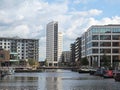 A view of of leeds dock with clarence house surrounded by modern apartment developments and bars with moored houseboats and blue