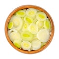 Leek slices, chopped leaf sheaths in a in wooden bowl