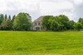 Large private country house with a green trimmed lawn. Sunny summer day and blue sky