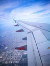 A Left Aircraft wing flying on the sky above the city. Royalty Free Stock Photo