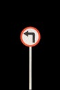 Left arrow with red edge circular badge with old rusted iron pole. Traffic sign signage. isolated with black background Royalty Free Stock Photo