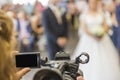 Screen and part of a video camera of an operator taking an event or a wedding. Royalty Free Stock Photo
