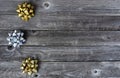 Left border of silver and gold bows on wooden background for a merry Christmas or happy New Year holiday celebration concept Royalty Free Stock Photo