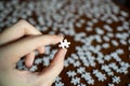 Left hand holding a piece of white jigsaw puzzle Royalty Free Stock Photo