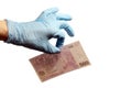 The left hand of a man in a blue rubber glove holds five hundred euros with two fingers. The concept of corruption in medicine, sc Royalty Free Stock Photo