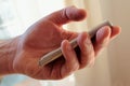 Left hand of man holding white silver cell mobile phone Royalty Free Stock Photo