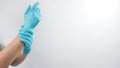 Left hand is pulling blue latex gloves of right hand on white background Royalty Free Stock Photo