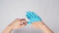 Left hand is pulling right hand with blue latex gloves on white background Royalty Free Stock Photo