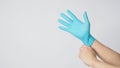 Left hand is pulling right hand wearing blue latex gloves on white background Royalty Free Stock Photo