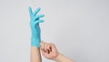 Left hand is pulling right hand wearing blue latex gloves on white background Royalty Free Stock Photo