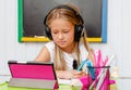 Left handed cute school girl studying online. Home education