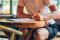 Left handed man hand with pen writing on notebook Royalty Free Stock Photo