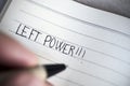 Left-handed man handwriting the text left power Royalty Free Stock Photo