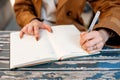 left - handed person writing on a notebook in cafe Royalty Free Stock Photo