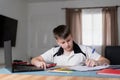 Left handed schoolboy writing and doing his homework Royalty Free Stock Photo