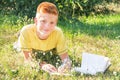 Left-handed teen lying and reading on the grass. Royalty Free Stock Photo