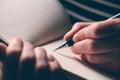 Left-handed woman writing diary