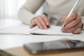 Left-handed woman writing in notebook at table indoors, closeup Royalty Free Stock Photo