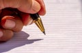 Left handed writing with a gold pen Royalty Free Stock Photo