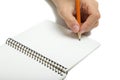Left-hander writes in a notebook Royalty Free Stock Photo