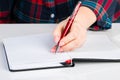 Left-handers Day. Business woman writes a note in notebook. Girl holds a pen in her left hand close-up