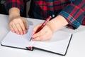 Left-handers Day. Business woman writes a note in notebook. Girl holds a pen in her left hand close-up