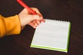 Left-handers Day. Business woman writes a note in notebook. Girl holds a pen in her left hand close-up