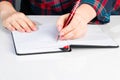 Left-handers Day. Business woman writes a note in notebook. Girl holds a pen in her left hand close-up