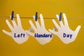 Left Handers Day message greeting across left hand silhouette cards hanging from pegs on a line