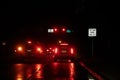 Left Lane MUST Turn Left - Motion blur of driving at night in the rain on a highway with lots of red and black - Abstract Royalty Free Stock Photo